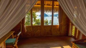 an empty room with a large window in a house at Elang Hillside Bamboo Villas in Labuan Bajo