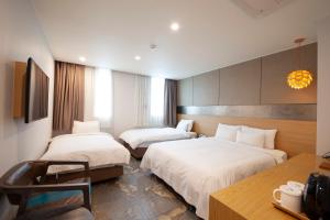 ソウルにあるホテル ナフォーレのベッド2台とデスクが備わるホテルルームです。