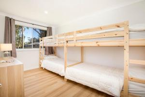 two bunk beds in a room with a window at Nautilus Pet Friendly 5 Mins Walk to Bay in Callala Bay