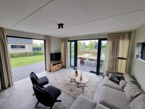 sala de estar con sofá, sillas y mesa en Luxurious detached water villa with jetty, en Balk
