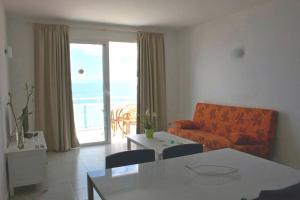 a living room with an orange couch and a table at Apartamentos El Guirre in Valle Gran Rey