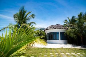 a small white building with a thatched roof at Ly Son Pearl Island Hotel & Resort in Ly Son