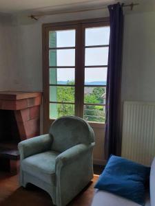 a living room with a chair and a window at Big summer house in the charming village of Meyssac in Meyssac