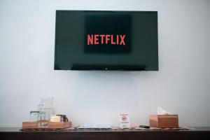 un televisor con las palabras netflix en una pared en Sare Homestay and Artspace Sanur, en Sanur