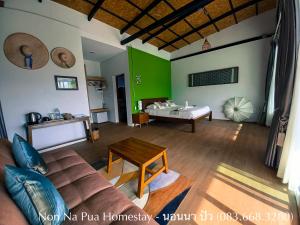 ein Wohnzimmer mit einem Sofa und einem Tisch in der Unterkunft NON NA PUA - นอนนา ปัว in Pua