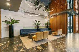 a lobby with a blue couch and chairs at Melbourne City Apartment Hotel in Melbourne