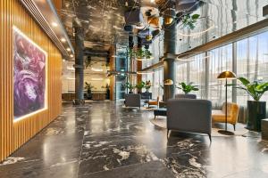 a lobby with chairs and plants in a building at Melbourne City Apartment Hotel in Melbourne