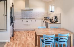a kitchen with a wooden table and blue chairs at Cozy Apartment In Sysslebck With Wifi in Sysslebäck