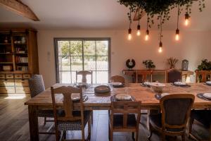 - une salle à manger avec une table et des chaises en bois dans l'établissement Proche PuyDuFou - Gite Maison La Roulière, à Saint-Aubin-de-Baubigné