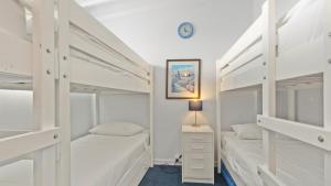 a bedroom with two bunk beds and a clock on the wall at Razorback 6 in Mount Hotham