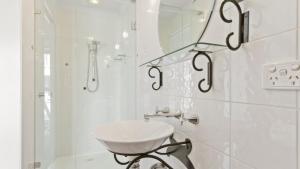 a white bathroom with a sink and a shower at Razorback 6 in Mount Hotham +8 photos