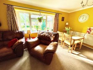 een woonkamer met een leren bank en een tafel bij Spacious 2 bed flat. in Whittington