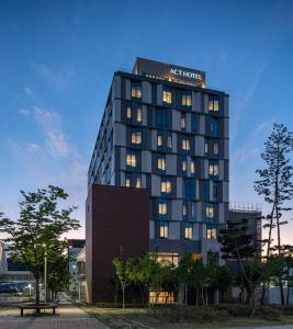 wysoki budynek z znakiem na górze w obiekcie Act Tourist Hotel w mieście Daegu
