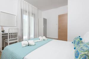 a bedroom with a bed with towels on it at Whitegold Apartments Panagia in Panagia