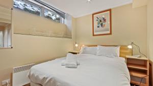 a bedroom with a large white bed and two windows at Razorback 7 in Mount Hotham +4 photos