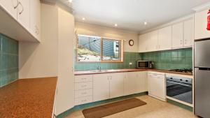 a kitchen with white cabinets and a window at Razorback 7 in Mount Hotham