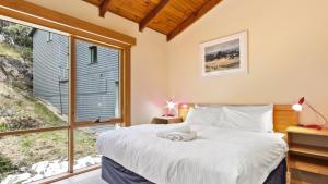a bedroom with a bed and a large window at Razorback 7 in Mount Hotham