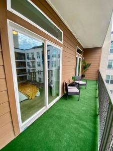 a balcony with green flooring on a house at Luxury Apartment Close to Everything w Free Parking 5 in Houston
