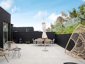 a patio with a table and an umbrella and chairs at 6 person holiday home in Gilleleje-By Traum in Gilleleje