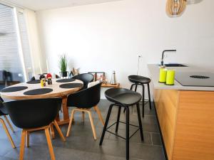 uma cozinha com uma mesa e algumas cadeiras pretas em Holiday home Hadsund CXXXI em Hadsund