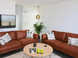 uma sala de estar com dois sofás castanhos e uma mesa em Holiday home Hadsund CXXXI em Hadsund