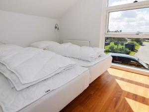 uma grande cama branca num quarto com uma janela em Holiday home Hadsund CXXXI em Hadsund