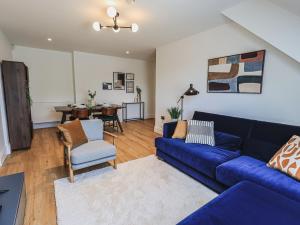 sala de estar con sofá azul y comedor en The Mabel Suite Stone Cross Mansion, en Ulverston
