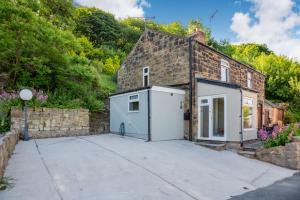 ein Backsteinhaus mit einer Garage neben einer Auffahrt in der Unterkunft 27 Green Road in Wrexham