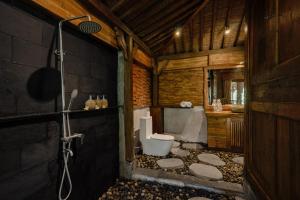 a bathroom with a shower and a toilet in it at Bubu Mesari Ubud Villa in Ubud