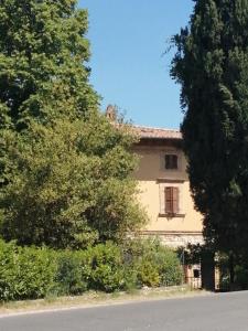 una casa con una ventana y árboles delante de ella en B&B La Giara di Assisi, en Asís