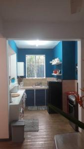 a small kitchen with blue walls and a sink at Apartment Pereybere in Grand-Baie