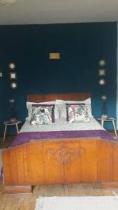 a bedroom with a wooden bed with blue walls at Apartment Pereybere in Grand Baie