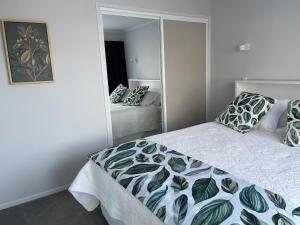 um quarto com uma cama e um espelho em Rotorua Central Hosted B&B em Rotorua