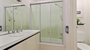 a bathroom with a sink and a glass shower at Shamrock 3 in Mount Hotham