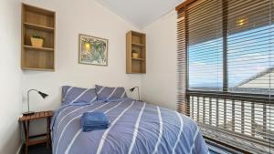 a bedroom with a bed and a large window at Shamrock 3 in Mount Hotham