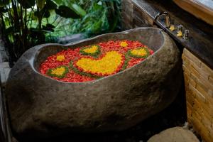 a bath tub filled with flowers in the shape of a heart at Bubu Mesari Ubud Villa in Ubud