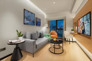 a living room with a couch and a table at Citadines Gaoxin Chengdu in Chengdu