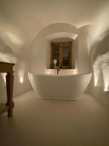 a white tub in a room with a window at Zamek Sarny - Schloss Scharfeneck in Kłodzko