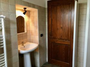 bagno con lavandino e porta in legno di Casale San Giovanni a Cura Nuova