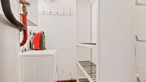 a white kitchen with a red appliance on a shelf at Snowtel 1 in Mount Hotham