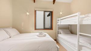 two beds in a room with two bunk beds at Snowtel 1 in Mount Hotham