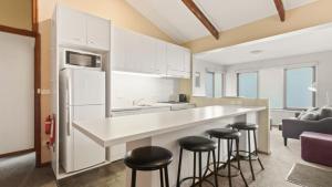 a kitchen with a counter and stools in a room at Snowtel 1 in Mount Hotham