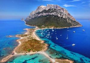 an island in the ocean with boats in the water at Tabula Apartments in Olbia