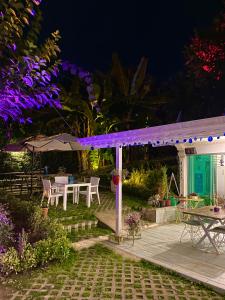 un patio trasero por la noche con luces moradas en una cubierta en Kadifeli Konak Hotel & Bungalow, en Kocaeli
