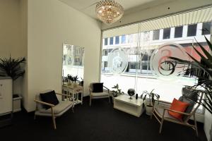 una sala de espera con sillas y una ventana grande en Siesta Sydney, en Sídney