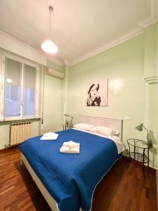 una camera con un letto blu e una finestra di B&B Santi Quattro Al Colosseo a Roma