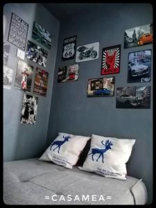 Sibu-Casamea(Shoplot)2 Bedrooms-FREE wifi & Washer في سيبو: غرفة نوم مع صور على الحائط وسرير مع وسائد