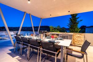 a dining room with a table and chairs on a patio at Villa Mezano in Žman
