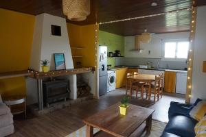 een keuken en een woonkamer met een open haard en een tafel bij Maison champêtre et joyeuse à la campagne in Berenx
