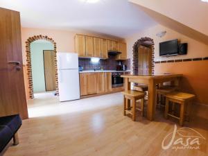 een keuken met een witte koelkast en een tafel bij Apartments Jasa in Mozirje